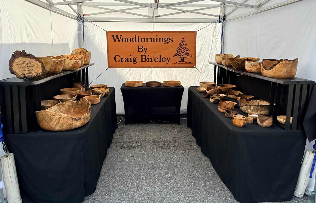Craig Bireley's booth display of hand-turned wooden bowls and vessels at a craft market